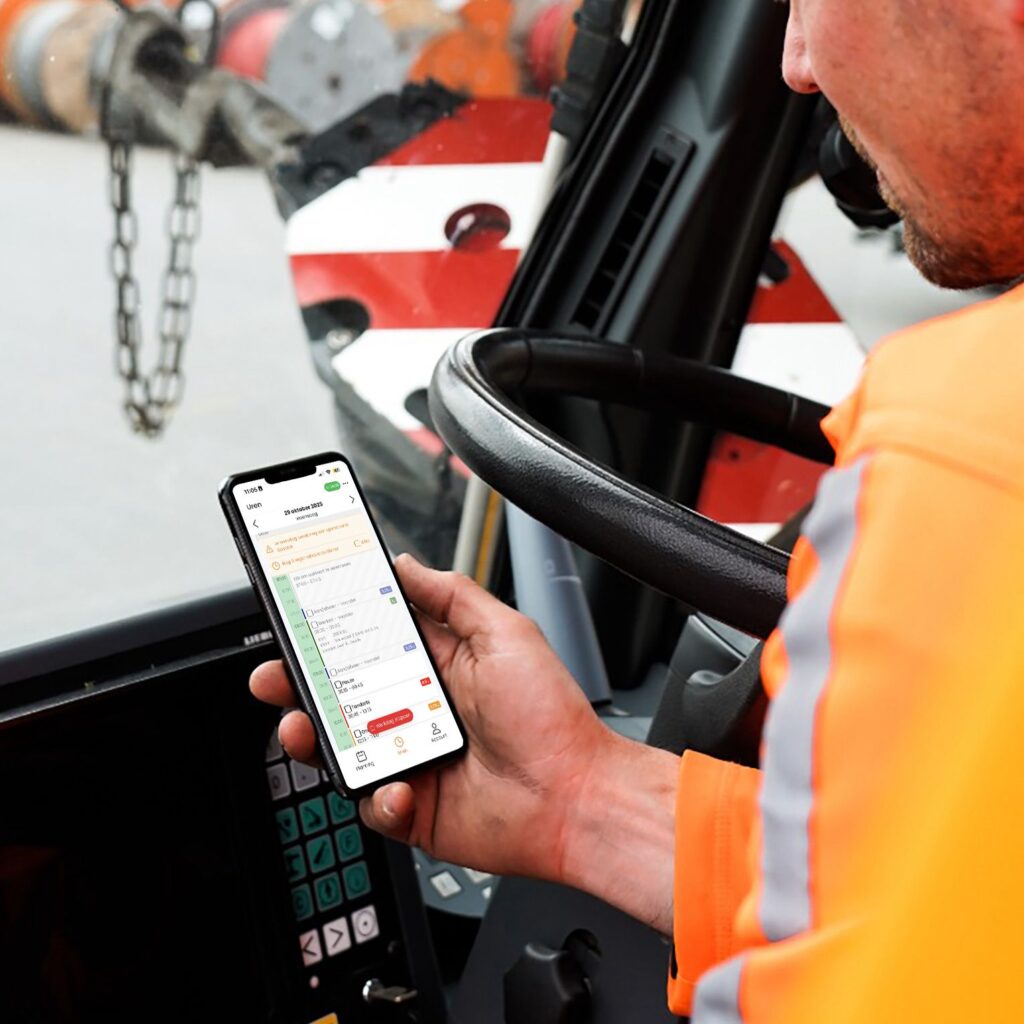 Een foto van een chauffeur op een kraan die de Uren app gebruikt